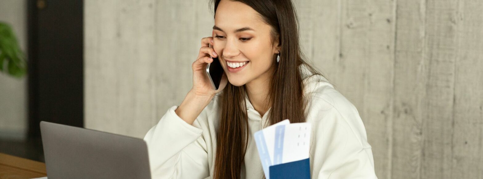 Femme souriante parlant au téléphone et tenant des documents, représentant une professionnelle du closing, un métier qui paie bien pour une femme en 2024