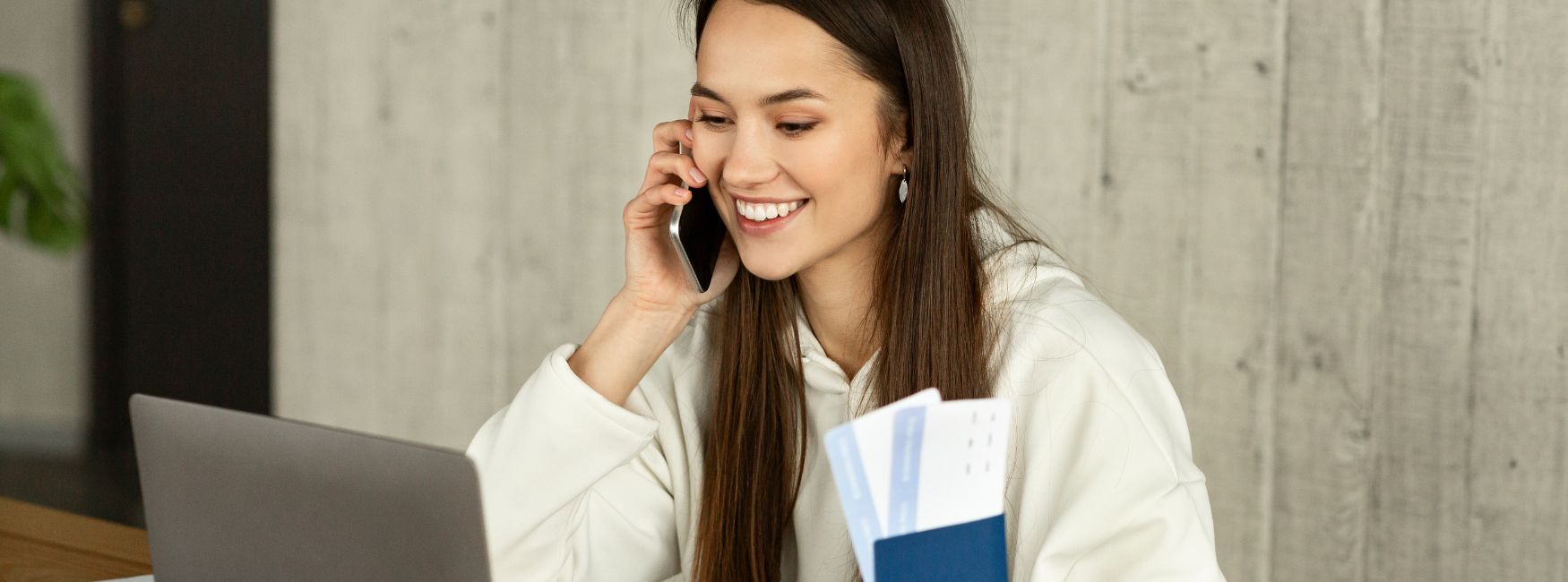 Femme souriante parlant au téléphone et tenant des documents, représentant une professionnelle du closing, un métier qui paie bien pour une femme en 2024